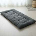 Gros plan sur le lit pour chien CoconPattes de couleur grise, montrant la texture moelleuse en peluche épaisse et la conception orthopédique matelassée.