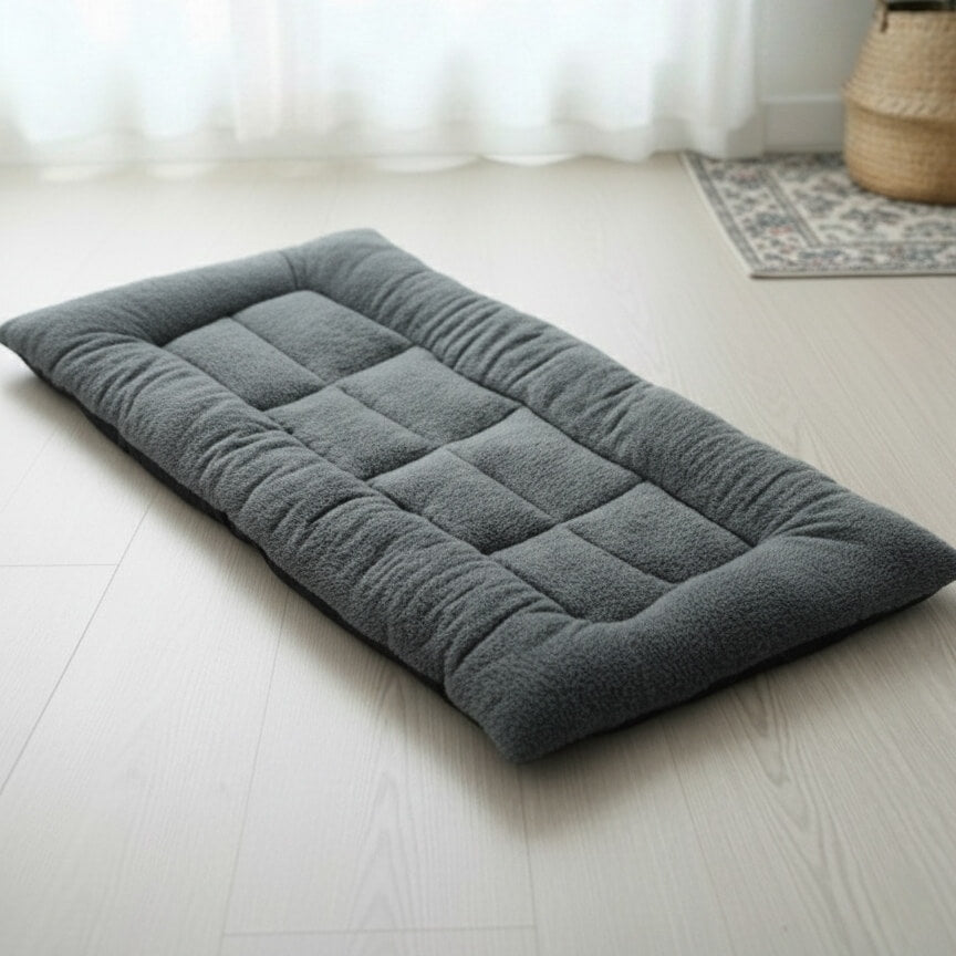 Gros plan sur le lit pour chien CoconPattes de couleur grise, montrant la texture moelleuse en peluche épaisse et la conception orthopédique matelassée.